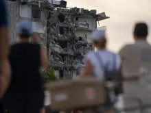 People watch the partially collapsed Champlain Towers in Surfside, Florida, north of Miami Beach.